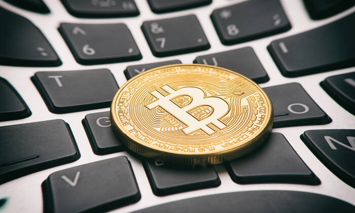 Golden bitcoin coin on keyboard