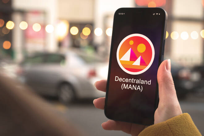 Decentraland MANA cryptocurrency symbol, logo. Business and financial concept. Hand with smartphone, screen with crypto icon close-up