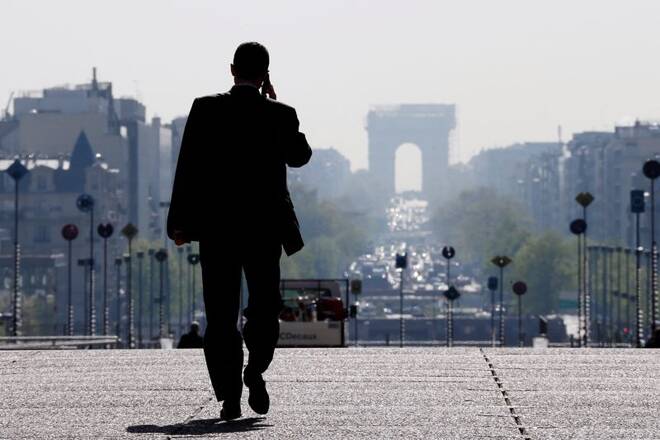 A businessman walks on the esplanade of La Defense, in the financial and business district west of Paris