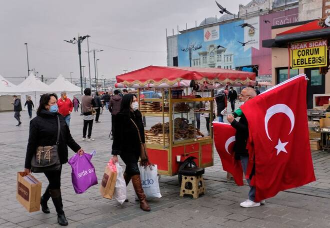 Shoppers carry bags as they stroll at the Eminonu district in Istanbul