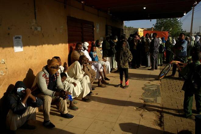 People gather outside a bakery to get bread in Khartoum North