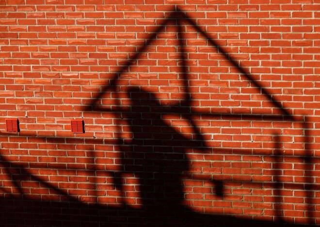 A construction worker casts a shadow as he works on a Taylor Wimpey housing estate in Aylesbury