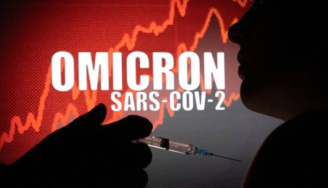 People pose with syringe with needle in front of displayed words "OMICRON SARS-COV-2