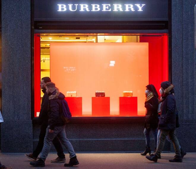 Shoppers walk past a store of fashion company Burberry in Zurich
