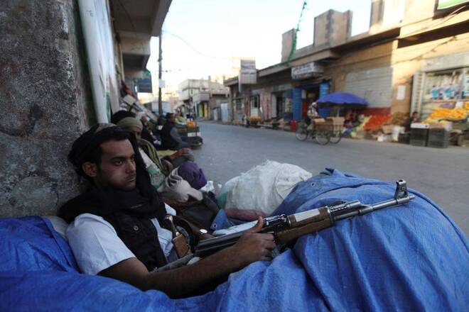 A Shi'ite Houthi fighter sits behind sandbags near a checkpoint in Sanaa