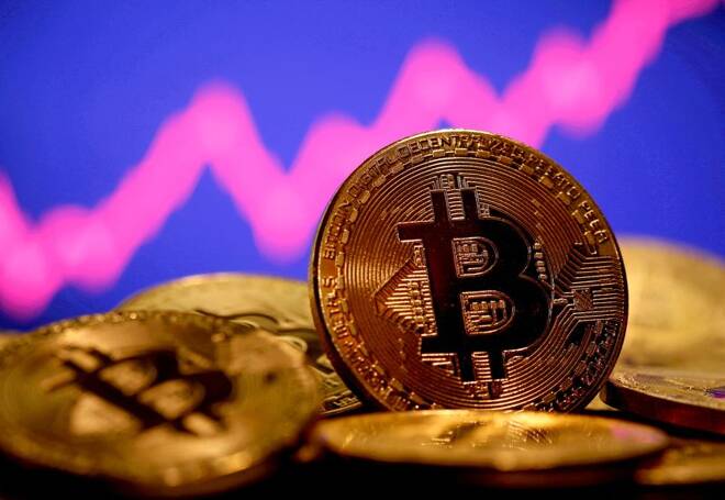 A representation of virtual currency Bitcoin is seen in front of a stock graph in this illustration taken