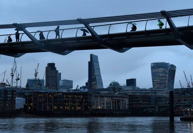 City workers cross the Millennium footbridge in the financial district of London