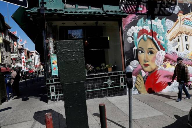 A man wearing a face mask walks through Chinatown Chinatown in San Francisco