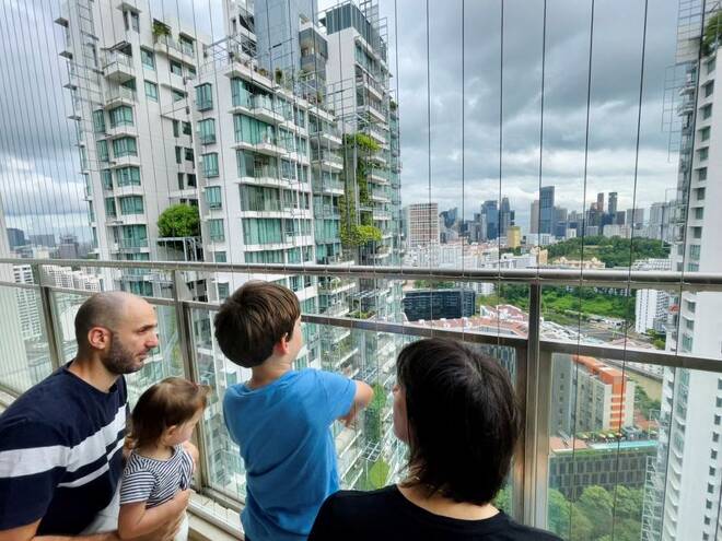 Israeli expatriate Atar Sandler and her husband speak to their children at the balcony of their apartment in central Singapore
