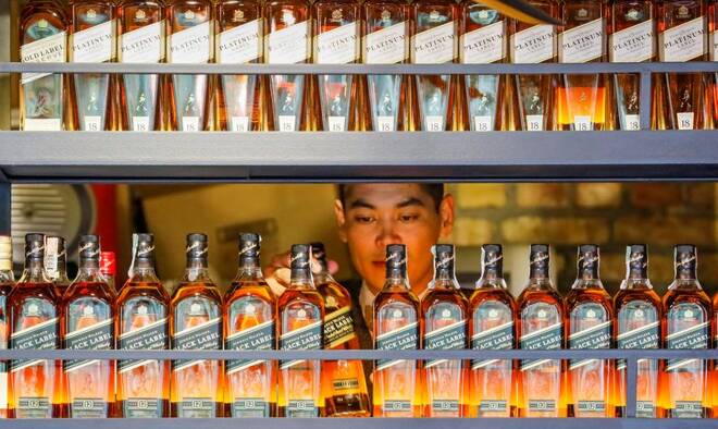 A bartender takes a bottle of Johnnie Walker whisky at Barmaglot bar in Almaty