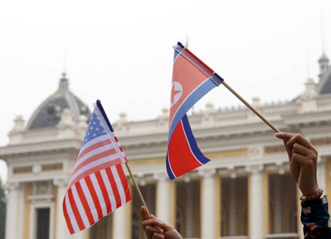 Residents hold US and North Korean flags while they wait for motorcade of North Korea's leader Kim Jong Un en route to the Metropole Hotel for the second US- North Korea summit in Hanoi