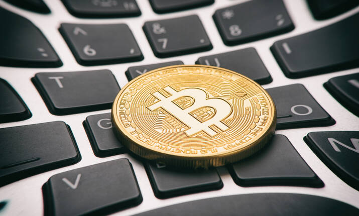 Golden bitcoin coin on keyboard