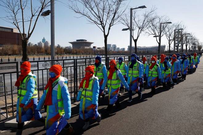 Volunteers walk outside the National Stadium where the opening ceremony of the Beijing 2022 Winter Olympics will be held in Beijing