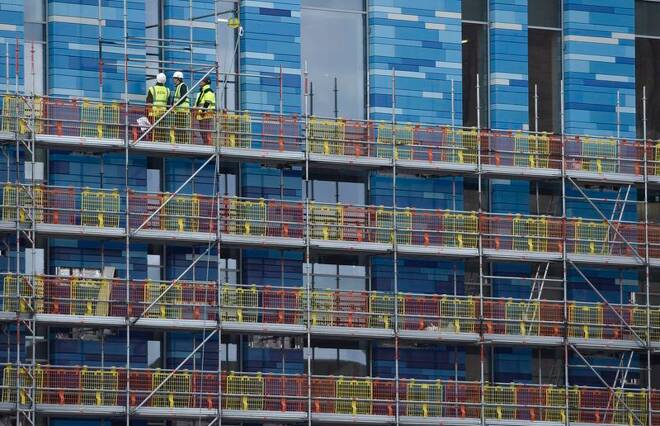 Workers stand on scaffolding on a new residential building at Battersea in London, Britain