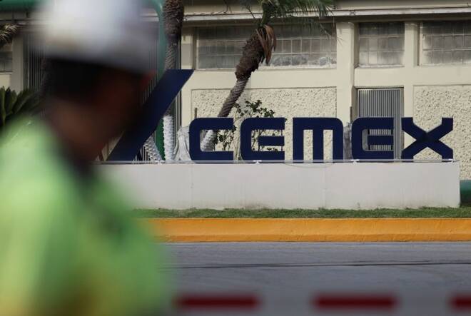 FILE PHOTO - A worker walks past outside the main entrance from a concrete plant of Mexican cement maker CEMEX, in Monterrey