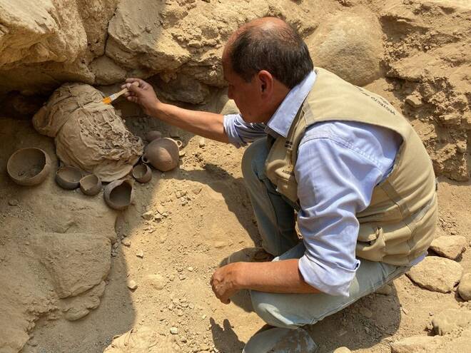 A Peruvian archeologist works at an excavation site to recover the remains of one of 14 pre-Incan mummies, six children and eight adults which are nearly 1000 years old, at the archeological complex in Cajamarquilla