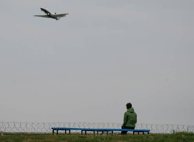 A woman looks on as business jet airplane takes off in Kyiv
