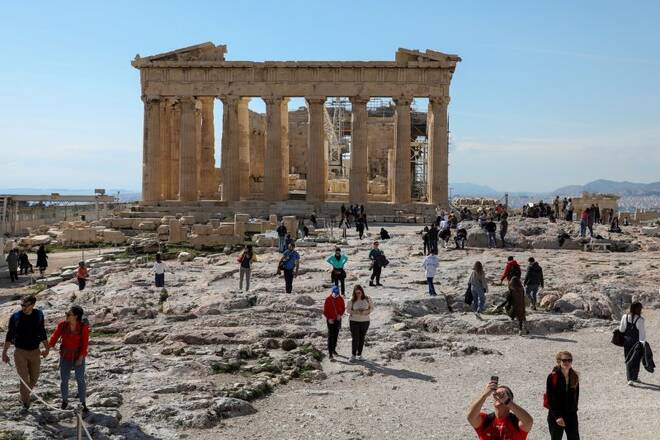 People visit the ancient Parthenon Temple atop the Acropolis hill archaeological site in Athens