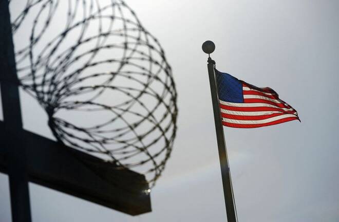 A U.S. flag flies above a razorwire-topped fence at the "Camp Six" detention facility at U.S. Naval Station Guantanamo Bay
