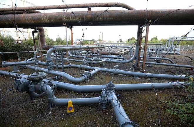 Sections of gas pipeline are seen next to a disused gas holder in Manchester