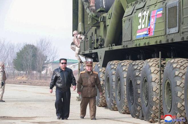 North Korean leader Kim Jong Un walks next to what state media reports is the "Hwasong-17" intercontinental ballistic missile (ICBM) on its launch vehicle