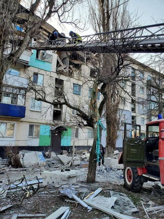Rescuers evacuate a person from a residential building damaged by military strike in Lysychansk
