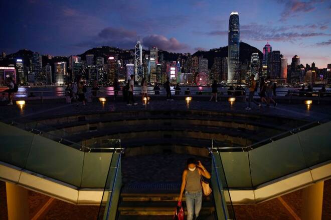 People enjoy the sunset view with a skyline of buildings during a meeting on national security legislation, in Hong Kong