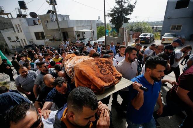 People carry the body of Palestinian woman, in Husan