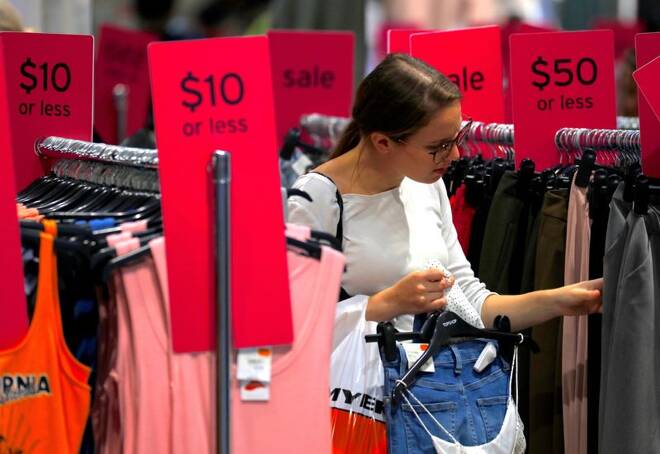 A shopper holds items and looks at others on sale at a clothing retail store in central Sydney, Australia