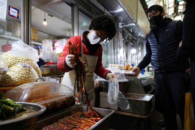 Choi Sun-hwa sells a traditional Korean side dish kimchi at her side dish store at a traditional market in Seoul