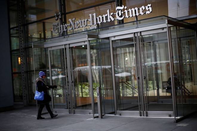 A woman walks into the New York Times building in New York