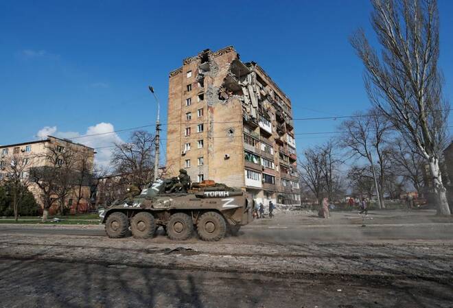Service members of pro-Russian troops ride an armoured personnel carrier in Mariupol