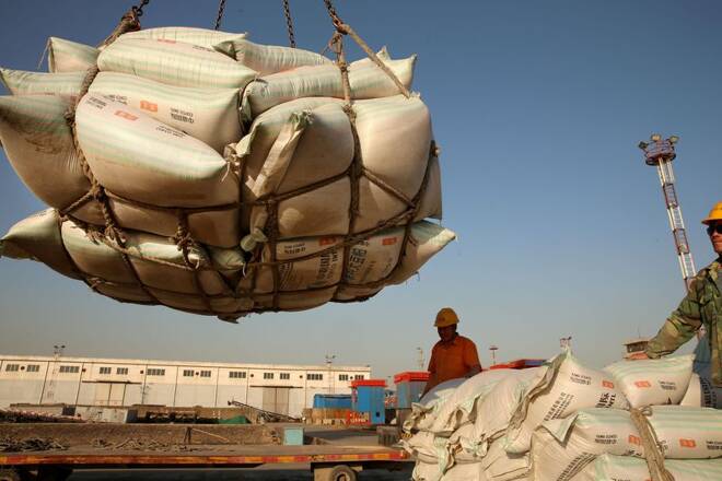 Workers transport imported soybean products at a port in Nantong