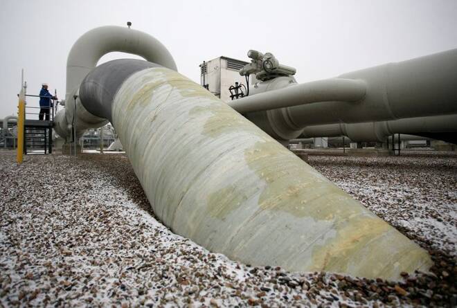 A technician stands beside a gas pipe at the WINGAS gas storage facility near the northern German town of Rehden