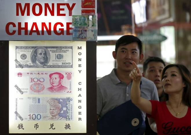 People look at the exchange rate at a Moneychanger displaying posters of U.S. dollars, Chinese Yuan and Malaysia Ringgit in Singapore