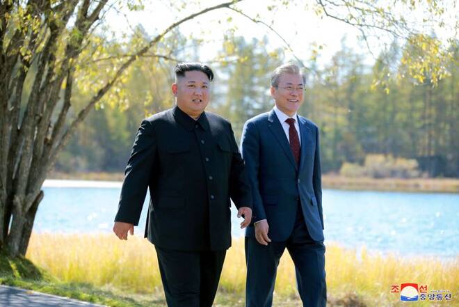 South Korean President Moon Jae-in and North Korean leader Kim Jong Un walk during a luncheon