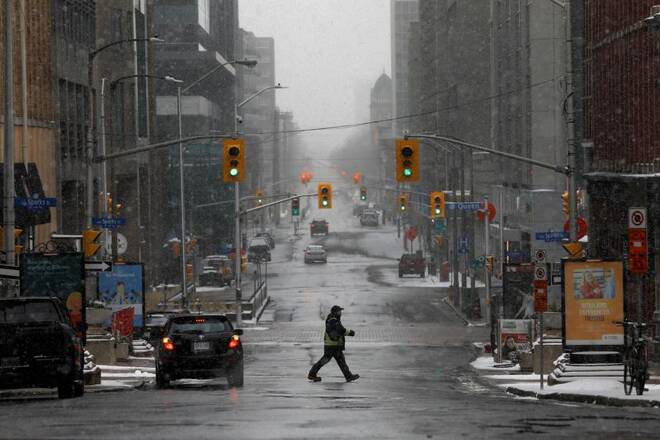 A pedestrian crosses a quiet downtown street as efforts continue to help slow the spread of coronavirus disease (COVID-19) in Ottawa