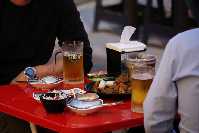 Businessmen enjoy fried chicken and beers at a pub in Seoul