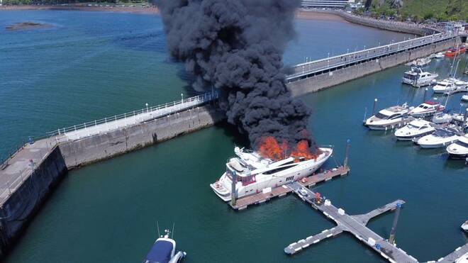 Thick black smoke rises from a fire on a yacht, at Torquay harbour