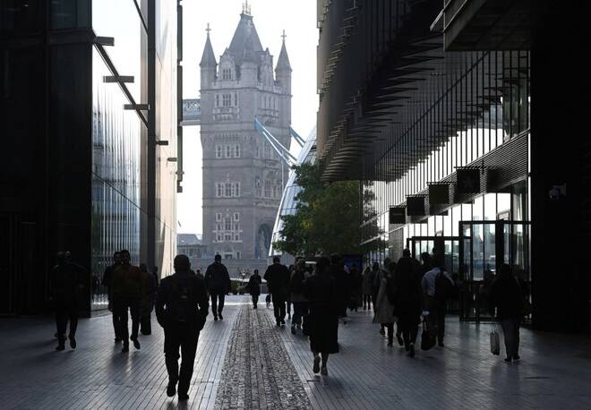 Workers walk towards Tower Bridge during the morning rush hour in London
