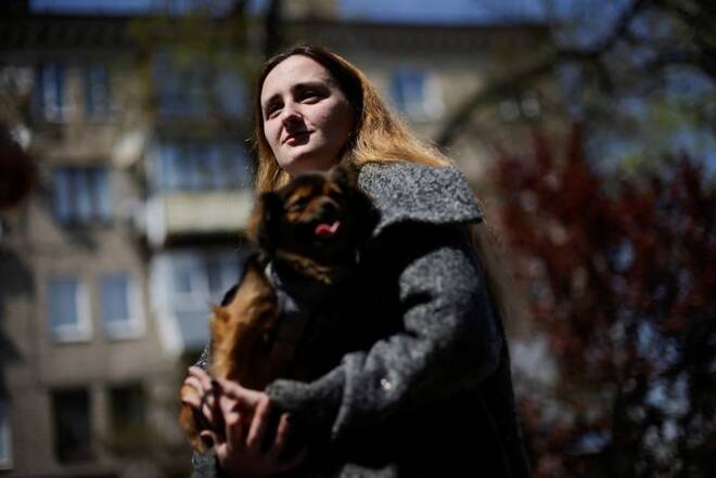 Tetyana Trotsak walks with her dog in front a hotel used as temporary shelter in Zaporizhzhia