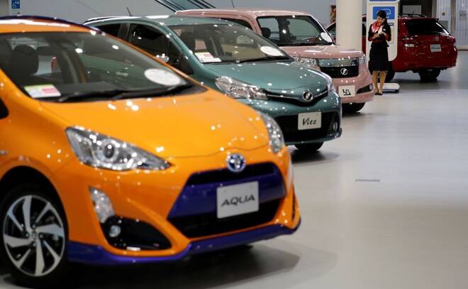 Employee stands among Toyota Motor Corp's cars at the company's showroom in Tokyo