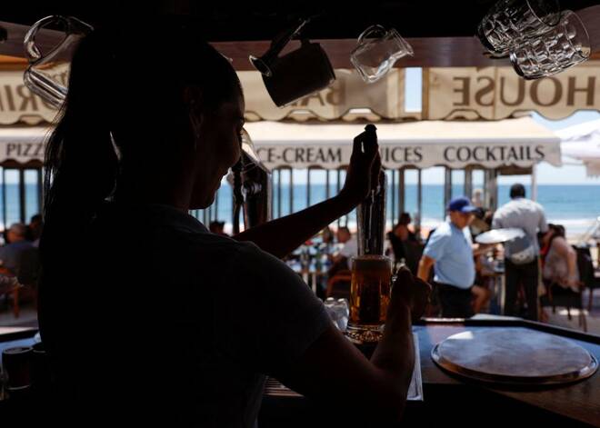 A waitress pours beer in a restaurant in Playa del Ingles, Maspalomas on the island of Gran Canaria