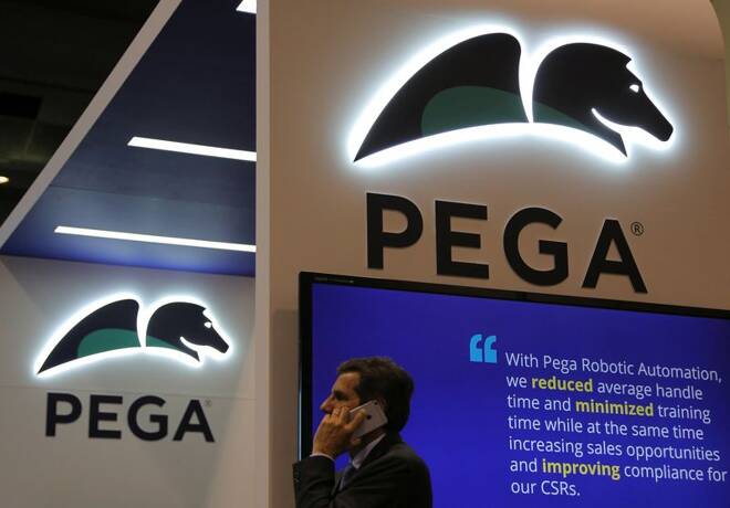 A man talks on the phone under a Pega logo at the Pegasystems booth at the SIBOS banking and financial conference in Toronto
