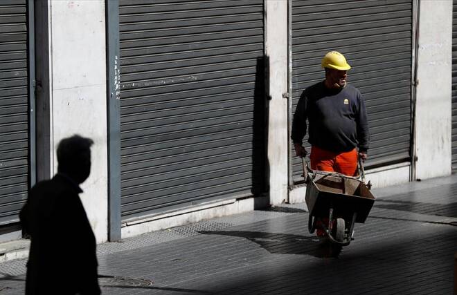 A construction worker uses a wheelbarrow amid a severe crisis of the economy