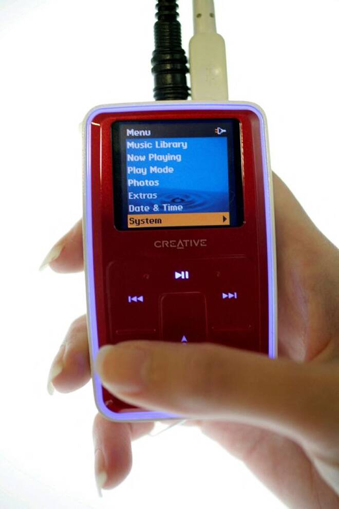 A staff poses with a Creative MP3 player in Singapore May 17, 2006. MP3 music player maker Creative'..