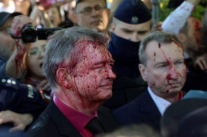 Russia's ambassador to Poland Sergey Andreev is covered in red substance thrown by protesters as he came to celebrate Victory day at the Soviet Military Cemetery in Warsaw