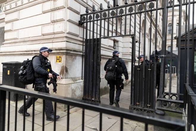 Police officers walk towards Downing Street in London