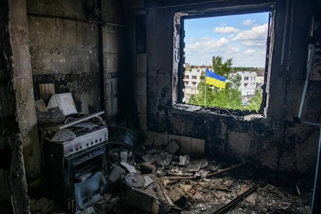 Ukrainian national flag is seen through the window of an apartment destroyed during Russia's invasion of Ukraine in the town of Borodianka