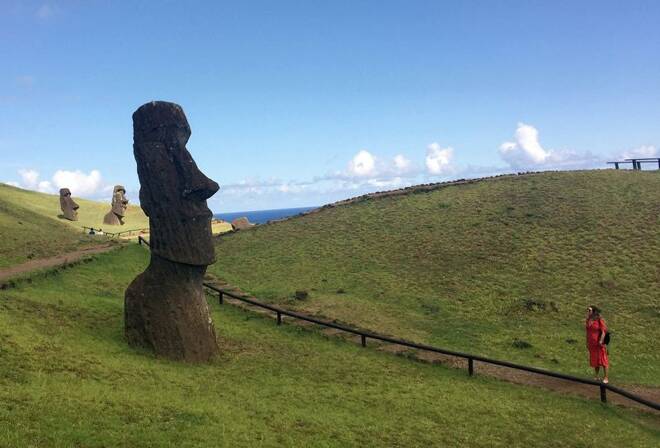 A tourist looks at a statue named "Moai" at Easter Island
